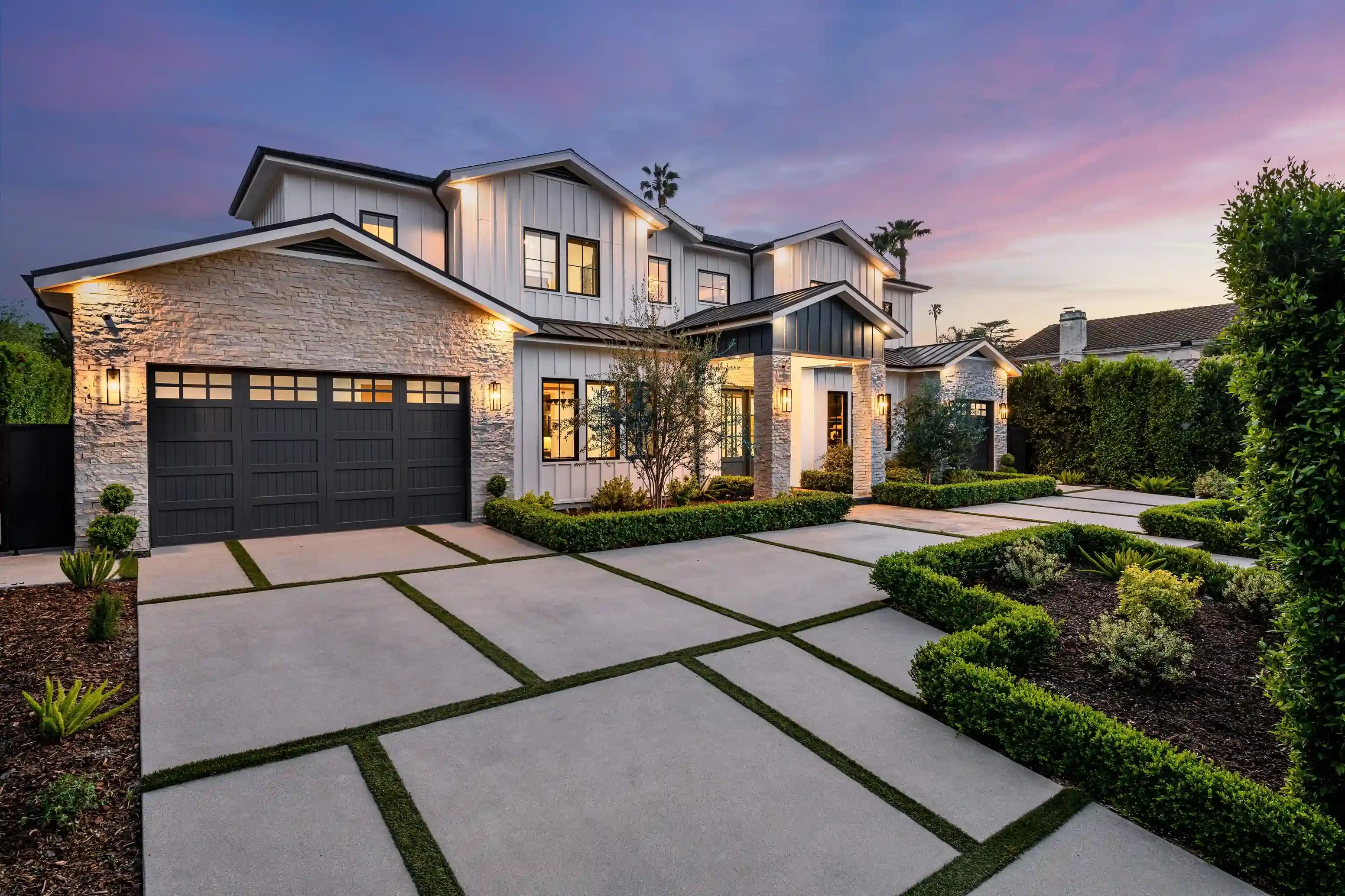Manicured front yard with stone path between hedges